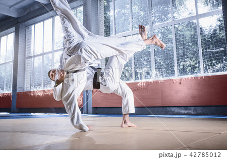 Two judo fighters showing technical skill while practicing martial arts in a fight club Two judo fighters showing technical skill while practicing martial arts in a fight club 42785012