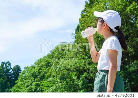 自然の中でペットボトルの水を飲む女性 自然の中でペットボトルの水を飲む女性 42792001