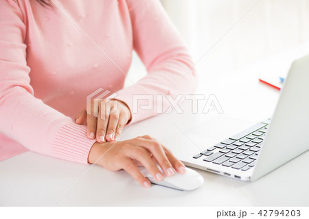 Woman holding her wrist pain from using computer 42794203