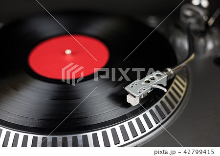 Professional party djs turntable with red and balck record. Analog stage audio equipment for concert Professional party djs turntable with red and balck record. Analog stage audio equipment for concert 42799415