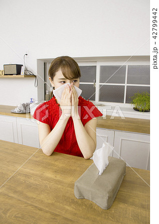 ティッシュペーパーで鼻をかむ女性 42799442