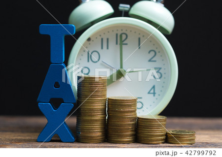 Time to pay TAX alphabet with coin and alarm clock 42799792
