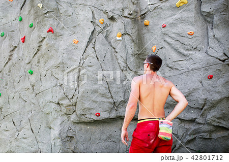 Photo from back of man climber in red shorts on background of boulder for rock climbing 42801712