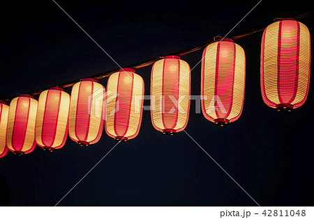 Paper red-white asian japanese chinese lanterns chochin akachochin shines on dark sky. A garland of 42811048