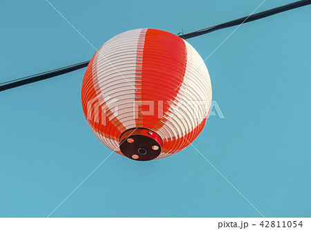 Paper red-white japanese lanterns Chochin hanging on blue sky background Paper red-white japanese lanterns Chochin hanging on blue sky background 42811054