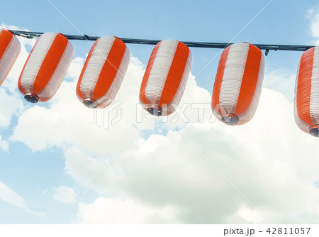Paper red-white japanese lanterns Chochin hanging on blue sky background Paper red-white japanese lanterns Chochin hanging on blue sky background 42811057