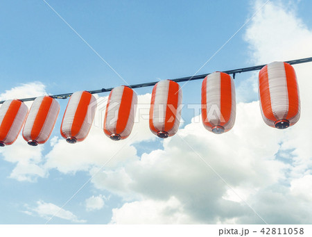 Paper red-white japanese lanterns Chochin hanging on blue sky background Paper red-white japanese lanterns Chochin hanging on blue sky background 42811058