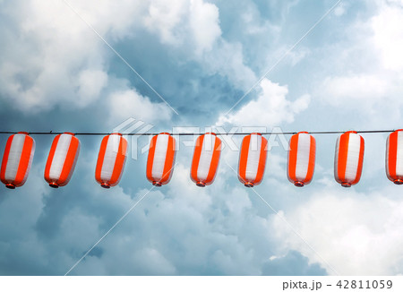 Paper red-white japanese lanterns Chochin hanging on blue sky background Paper red-white japanese lanterns Chochin hanging on blue sky background 42811059