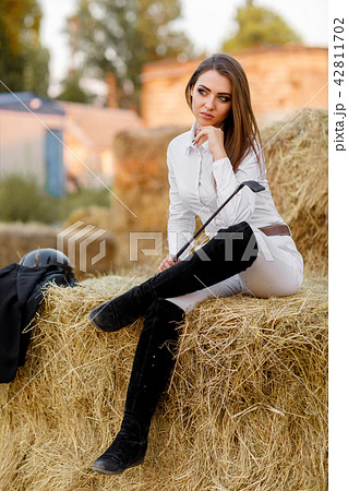 rider woman with whip is sitting on hay - Stock Photo [42811702] - PIXTA