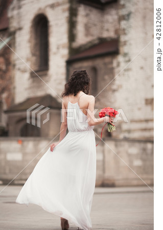 Beautiful young bride with bridal bouquet on the background church 42812006