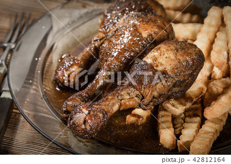 Fried chicken drumsticks with chips. 42812164