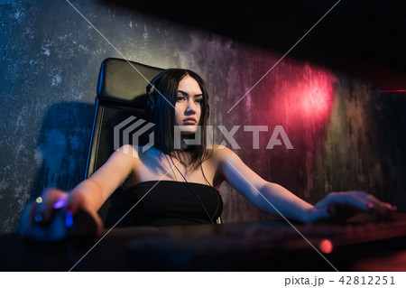 Concerned girl gamer in headphones playing network games preparing to participate in international Concerned girl gamer in headphones playing network games preparing to participate in international 42812251