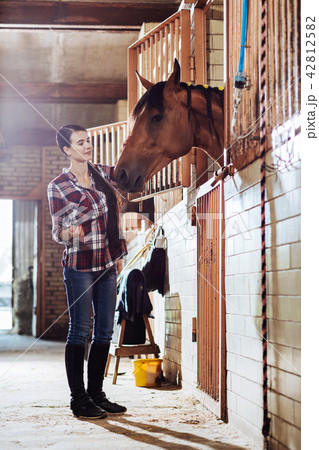 Beautiful woman with long dark braid coming to stable Beautiful woman with long dark braid coming to stable 42812582