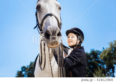 Dark-haired businesswoman loving equestrianism coming to race track 42812960