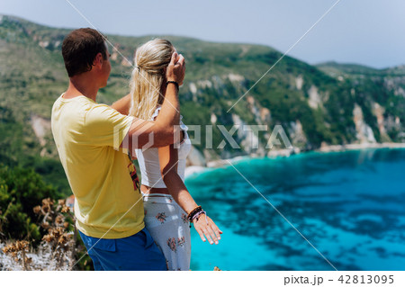 Birthday gift. Young man closing hes girlfriend eyes in front of gorgeous seascape panorama of blue 42813095