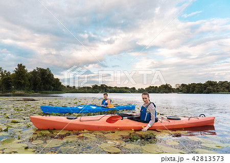 Loving couple enjoying beautiful landscape while rowing in canoe Loving couple enjoying beautiful landscape while rowing in canoe 42813573