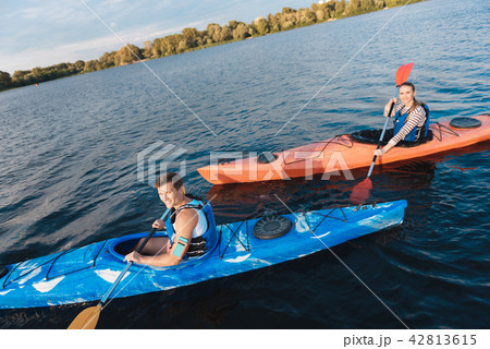 Beaming handsome sportsman a rowing in canoe Beaming handsome sportsman a rowing in canoe 42813615