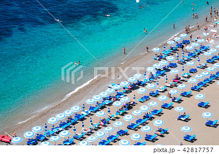 パラソルが並ぶビーチと紺碧のアマルフィ海岸の写真素材