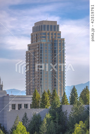 High rise seen from among the city and trees High rise seen from among the city and trees 42819761