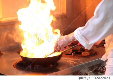 料理人が火をだしてフランベするイメージ画像の写真素材