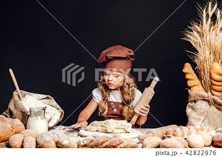 Little girl kneading dough at table Little girl kneading dough at table 42822976