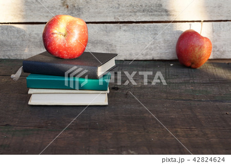 Apple on pile of books at the table 42824624