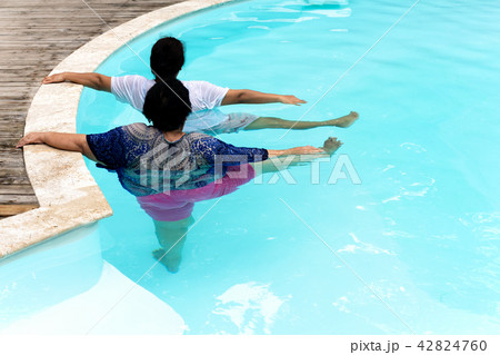 Two senior women doing aqua gym exercise in outdoor swimming pool. Two senior women doing aqua gym exercise in outdoor swimming pool. 42824760