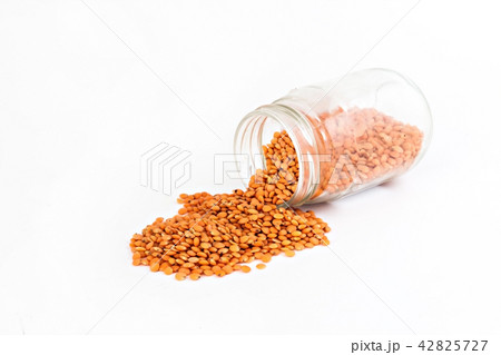 red lentils spilled from the container isolated 42825727