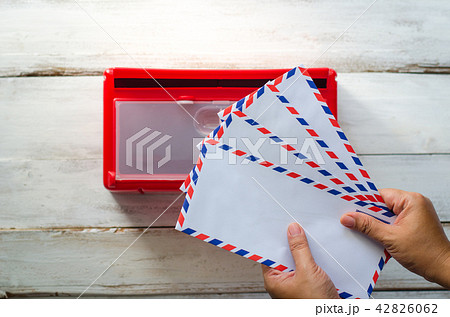 Hands are picking up the envelope in the mailbox. Hands are picking up the envelope in the mailbox. 42826062