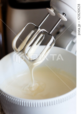 Electric mixer being used to mix ingredients for  42826628