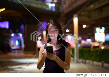 Beautiful Asian Woman Outdoors At Night Using Mobile Phone 42832131