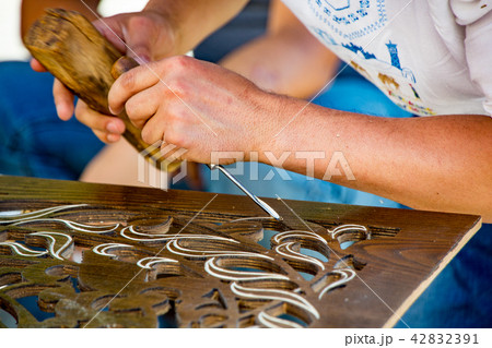Man chisels wood engraving in workshop near Chorsu 42832391