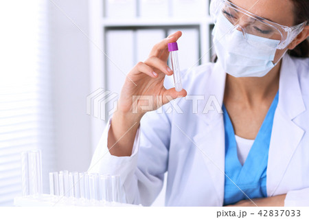 Female scientific research is looking at the tube in laboratory. Blood test concept Female scientific research is looking at the tube in laboratory. Blood test concept 42837033