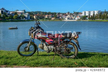 An old motorcycle with the lake An old motorcycle with the lake 42848972