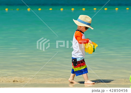 Two year old toddler playing on beach 42850456
