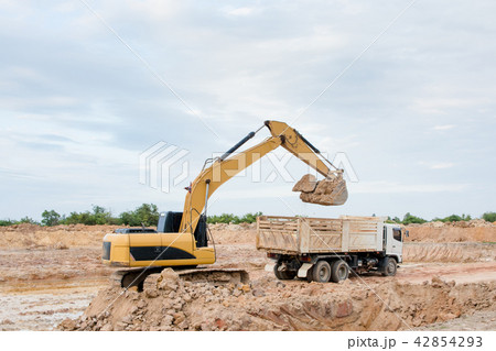 Yellow excavator machine loading soil into a dump Yellow excavator machine loading soil into a dump 42854293