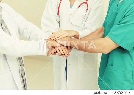 Doctor, surgeon and nurse join hands together. Doctor, surgeon and nurse join hands together. 42858613