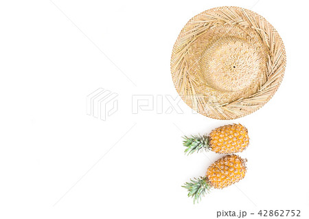 Tropical concept. Pineapple fruit and straw hat Tropical concept. Pineapple fruit and straw hat 42862752