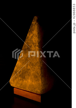 Salt lamp in the form of a pyramid in the darkness 42866653