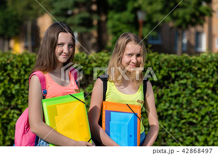 Two girls schoolgirl teenager in summer in park after school. Hands holding a folder of notebooks 42868497