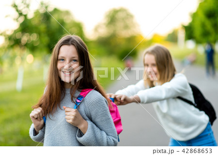 Two girl schoolgirl girlfriends. In the summer in city. Playing with each other. The concept of rest Two girl schoolgirl girlfriends. In the summer in city. Playing with each other. The concept of rest 42868653