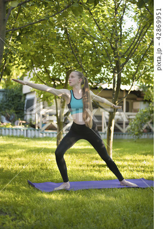 Pregnant woman in the garden practices yoga 42869951