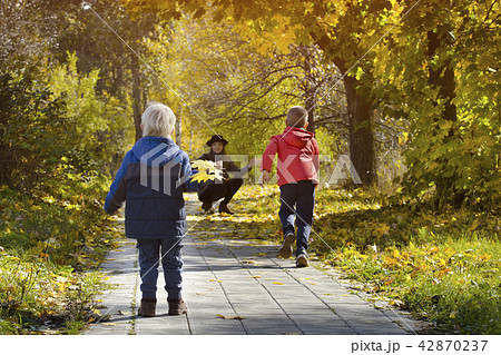 Boys running towards her mother. Autumn Park 42870237
