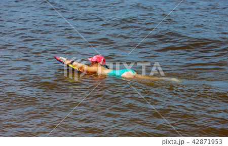 Adorable little girl on surfboard at the seashore Adorable little girl on surfboard at the seashore 42871953