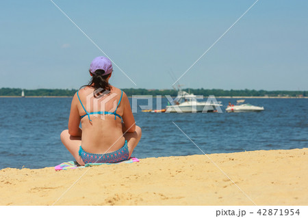 Attractive surf girl in is sitting on the beach Attractive surf girl in is sitting on the beach 42871954
