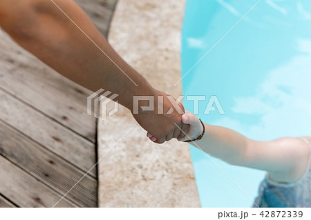 Man hand reach helpnig achild in a local pool on vacation. Man hand reach helpnig achild in a local pool on vacation. 42872339