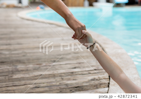 Man hand reach helpnig achild in a local pool on vacation. Man hand reach helpnig achild in a local pool on vacation. 42872341