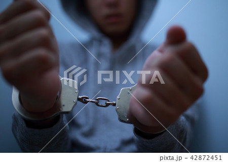 手錠 逮捕 犯罪 違法 犯人 悪人 容疑者 事件 犯罪者 不審者 侵入 泥棒 顔なし 凶悪犯 の写真素材