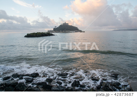 朝日を浴びる雲の下のセントマイケルズマウントと海岸 42873687