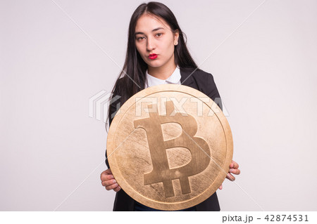 Crypto currency, web money and blockchain concept - Serious asian woman with red lips and a huge Crypto currency, web money and blockchain concept - Serious asian woman with red lips and a huge 42874531